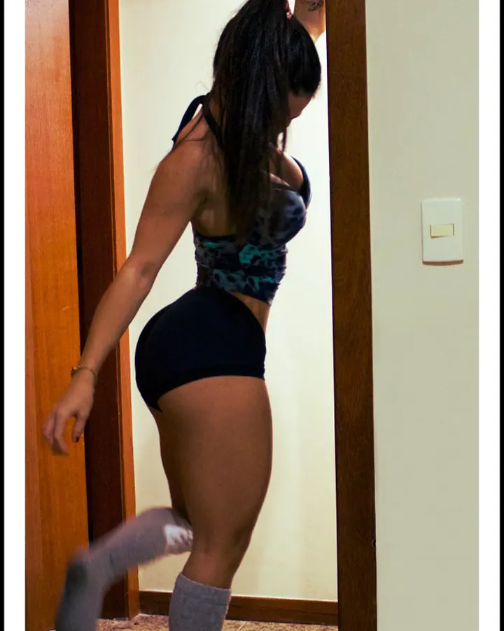 Femme de dos en tenue sport, cheveux noirs en queue-de-cheval, pieds en chaussettes grises