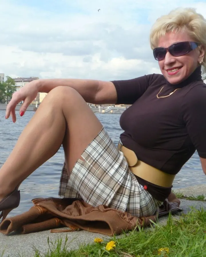 Femme en robe imprimée, debout dans une pièce, main sur la hanche