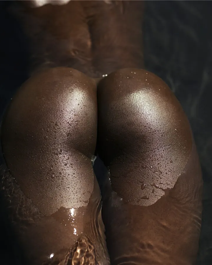 Plan rapproché sur les fesses d'une femme noire dans l'eau, gouttelettes visibles